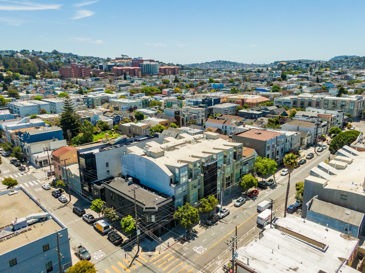 A vibrant San Francisco neighborhood with new condos and older buildings side by side, illustrating gentrification and urban change.