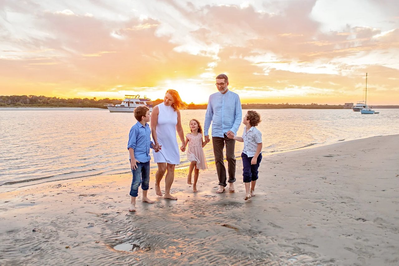 Mother and Father with three children on the beach on the emerald coast of florida