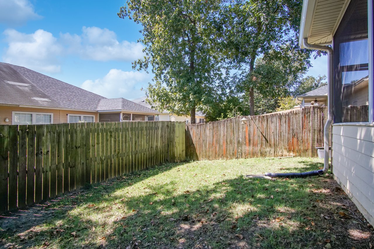 Backyard at 5441 Hampton Hill Circle, Tallahassee, Florida 32311 featuring privacy fence, lawn, and screened porch exterior.