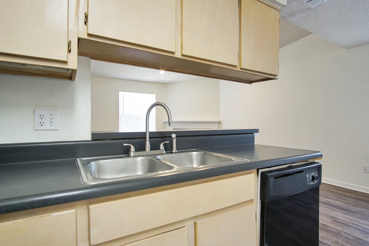 A modern kitchen featuring a sink and a refrigerator, showcasing a clean and functional design.