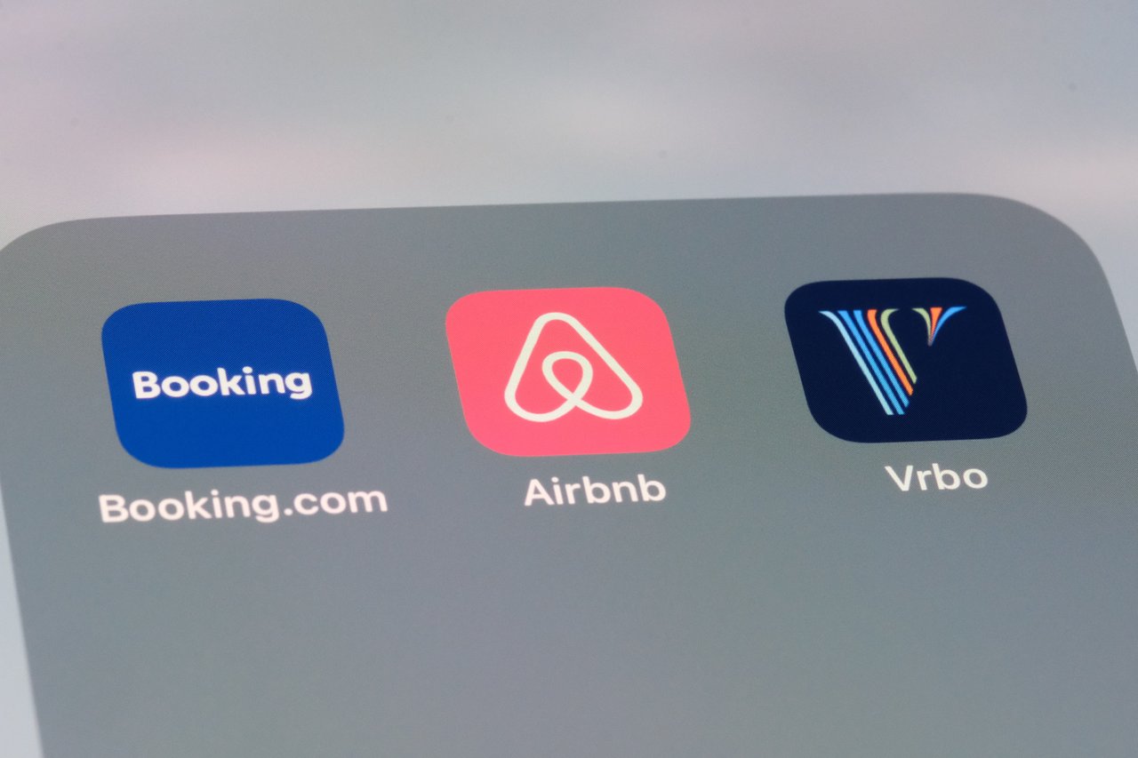 Booking.com, Airbnb, and Vrbo app icons side by side on a smartphone home screen