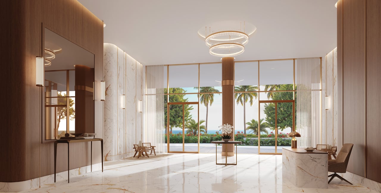 The Berkeley condominium lobby with marble finishes, a circular chandelier, and ocean views through tall windows.