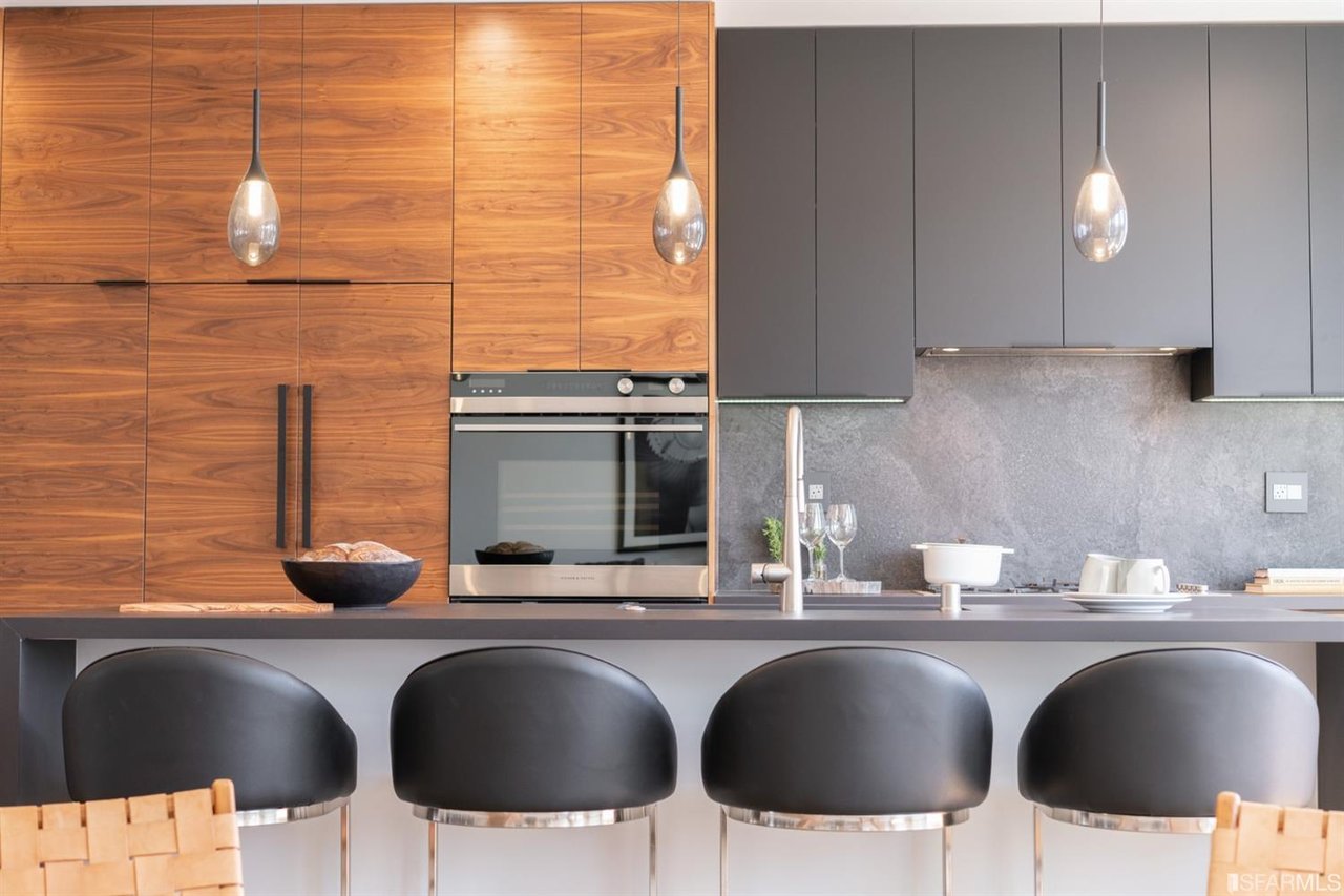 Modern kitchen with wood cabinets, stainless steel appliances, and island seating