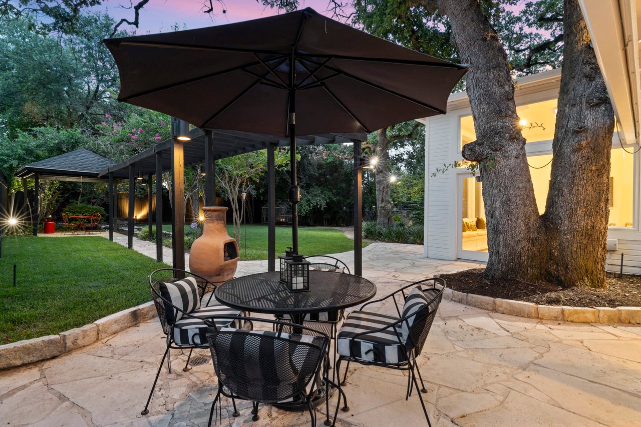 Twilight patio with umbrella table and pergola structure, Tarrytown, Austin.