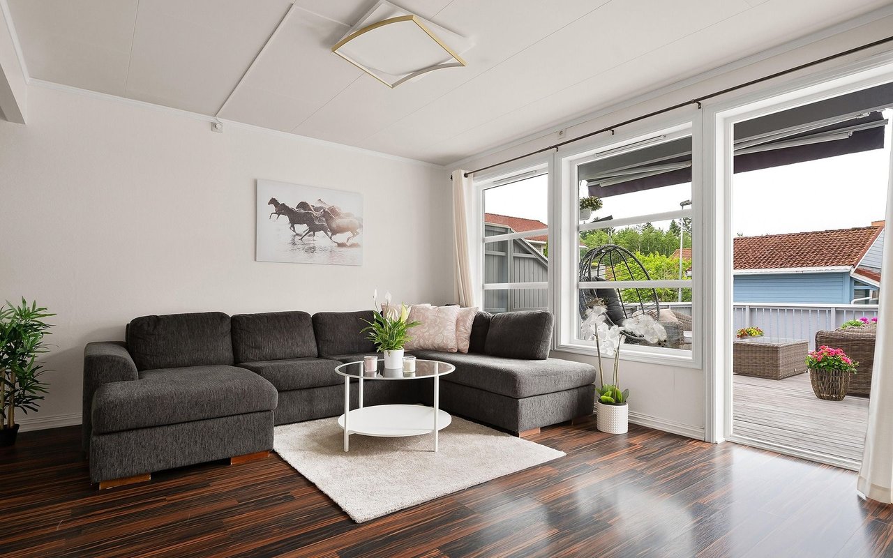 Living room with a dark gray sectional and sliding glass doors opening onto a deck.