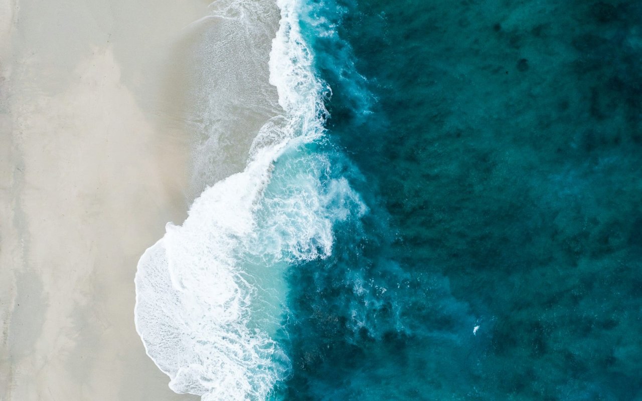 An aerial view of a sandy beach meeting the ocean.