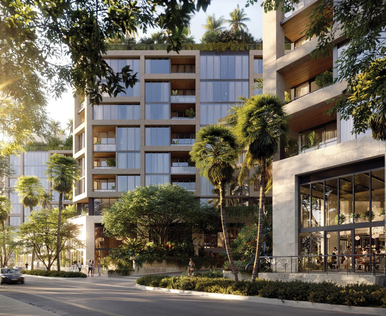 Modern Coconut Grove condominium with glass balconies, tropical landscaping, and a street-level entrance.