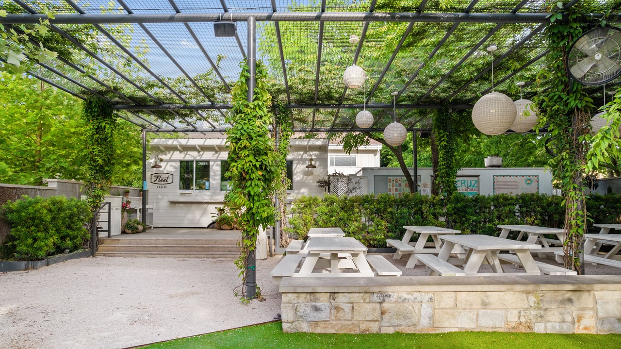 Nearby neighborhood lifestyle photo of an outdoor patio with pergola, string lights, and picnic seating close to 34 Margranita Crescent in Tarrytown, Austin, TX.
