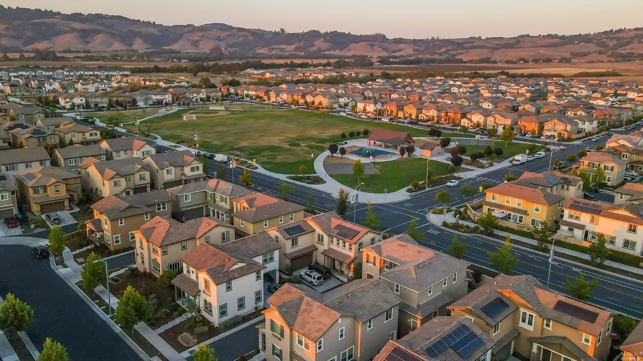 Aerial view of Petaluma homes surrounding a green park, with rolling hills beyond.