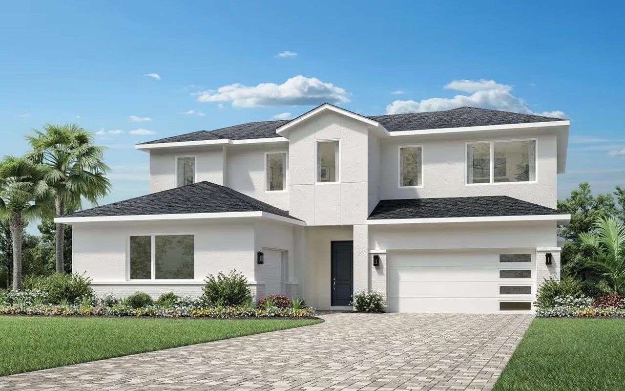 Modern two-story white house with a wide garage, landscaped front garden, and stone-paver driveway.