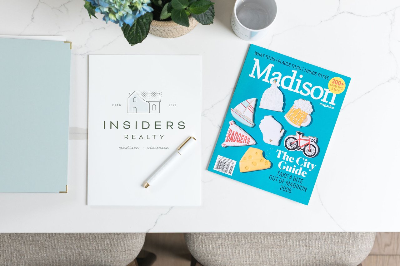 Insiders Realty branding alongside a Madison magazine on a bright desktop, representing the September 2026 Dane County housing market update and local Madison real estate expertise.