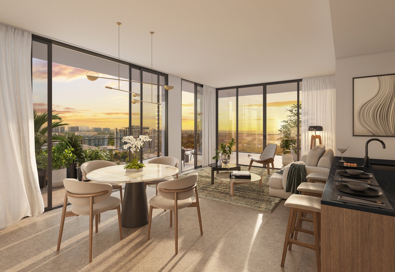 Open-plan condo living and dining area with floor-to-ceiling windows overlooking the city at sunset.