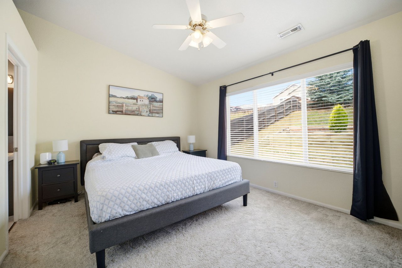 Primary Bedroom with vaulted ceilings, ceiling fan, walk-in closet and ensuite bath