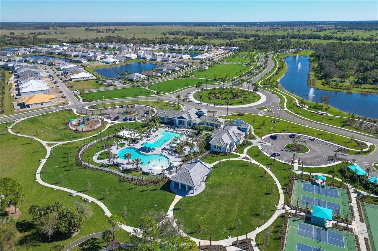 Aerial view of Grand Park with community pools, tennis courts, walking paths, and a lake.