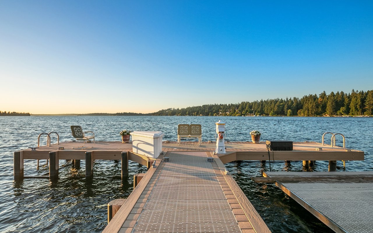 A peaceful scene of a wooden dock on a lake, surrounded by trees