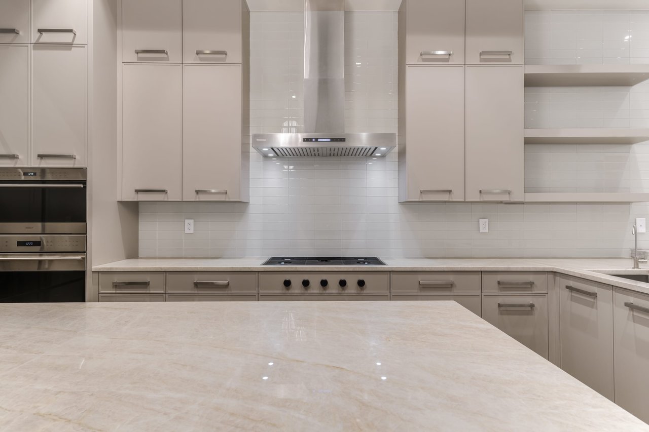 Chic, modern kitchen highlighting elegant grey cabinetry and crisp white countertops, offering a refined culinary atmosphere.