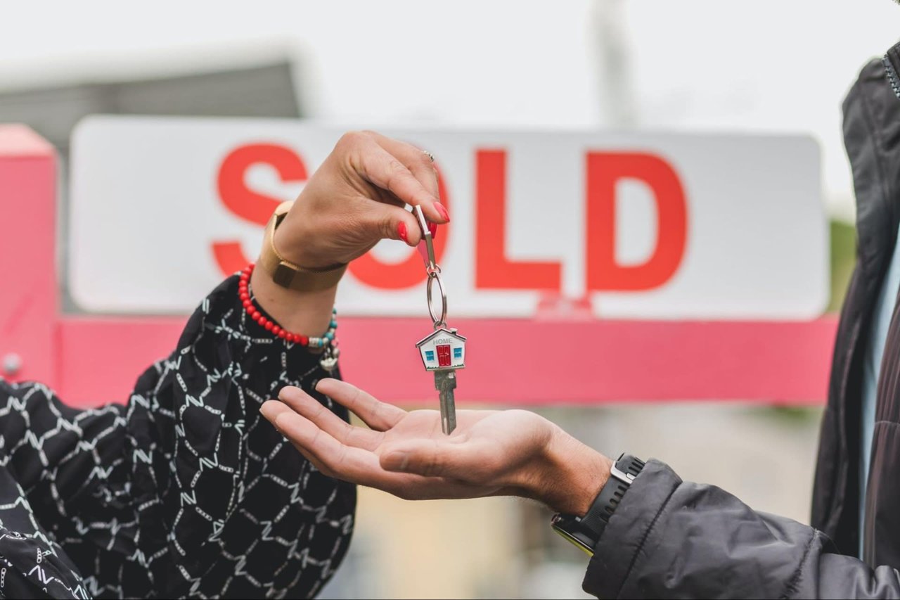 realtor handing out the home key to the real estate buyer