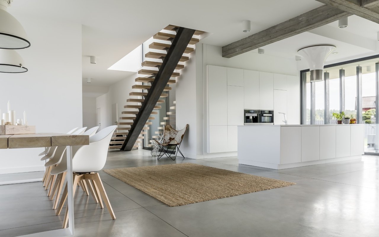 A kitchen with a white island, stainless steel appliances, and a lot of natural light