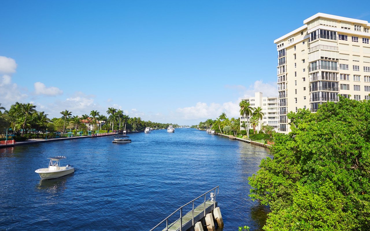 A canal with boats and a tall building in the background