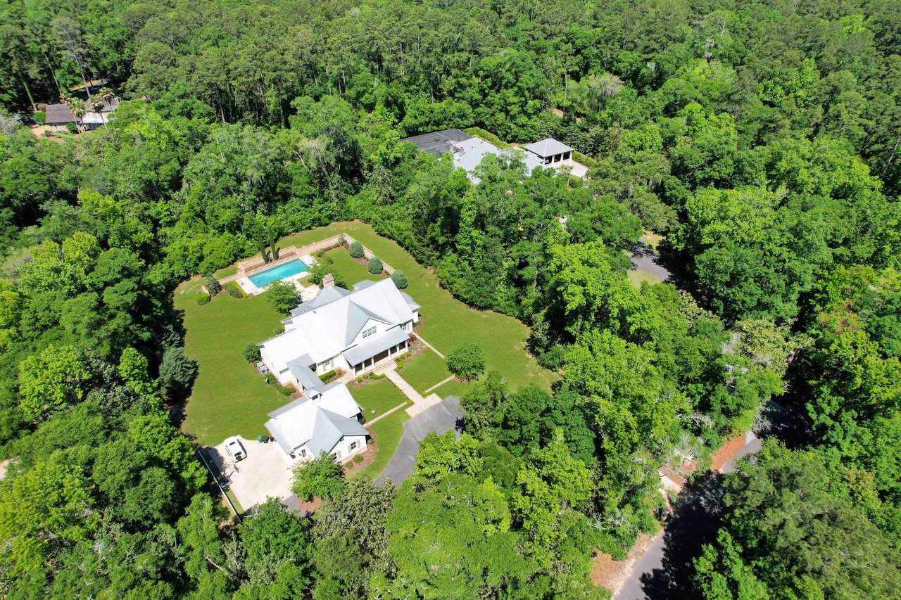 An aerial view of a large, luxurious property in the Bobbin Brook community, surrounded by dense trees and greenery.