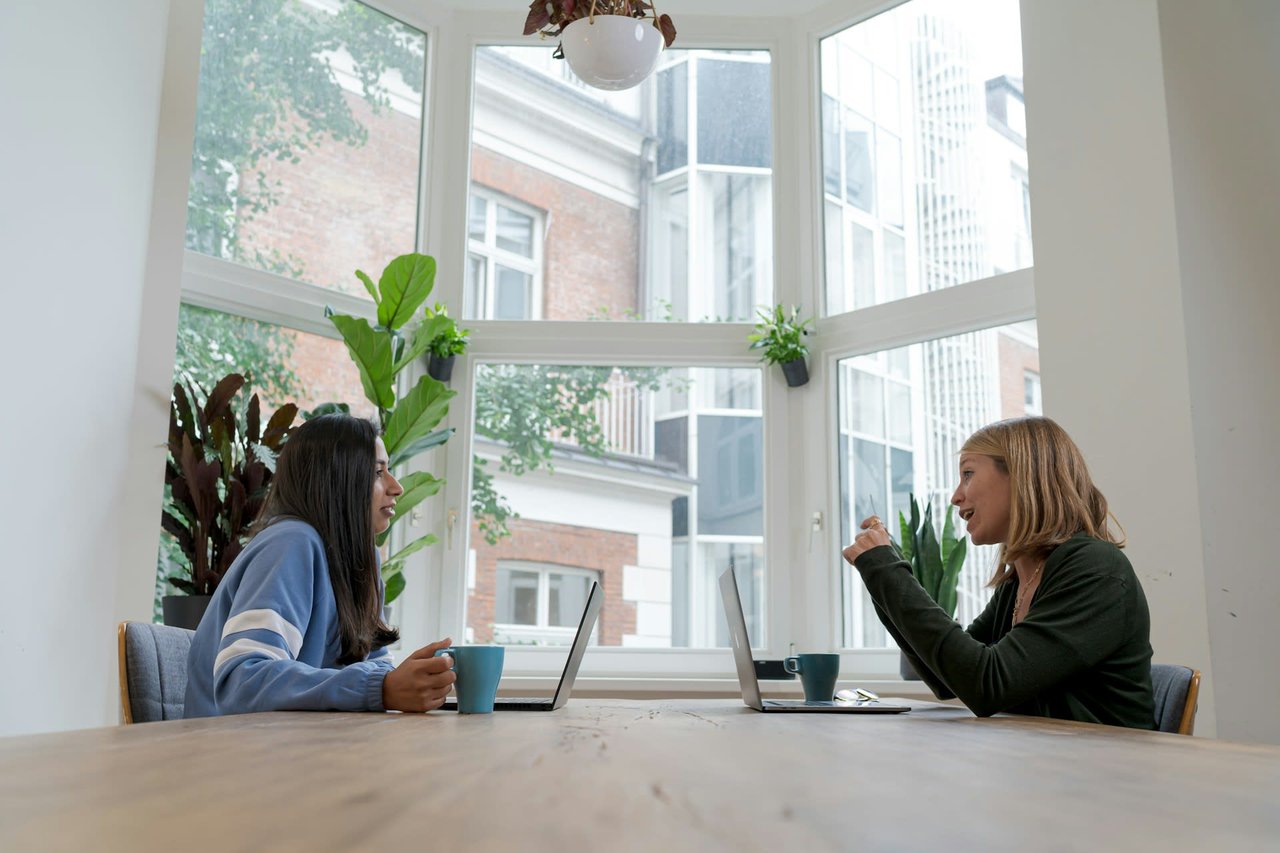 two women talking inside apartment