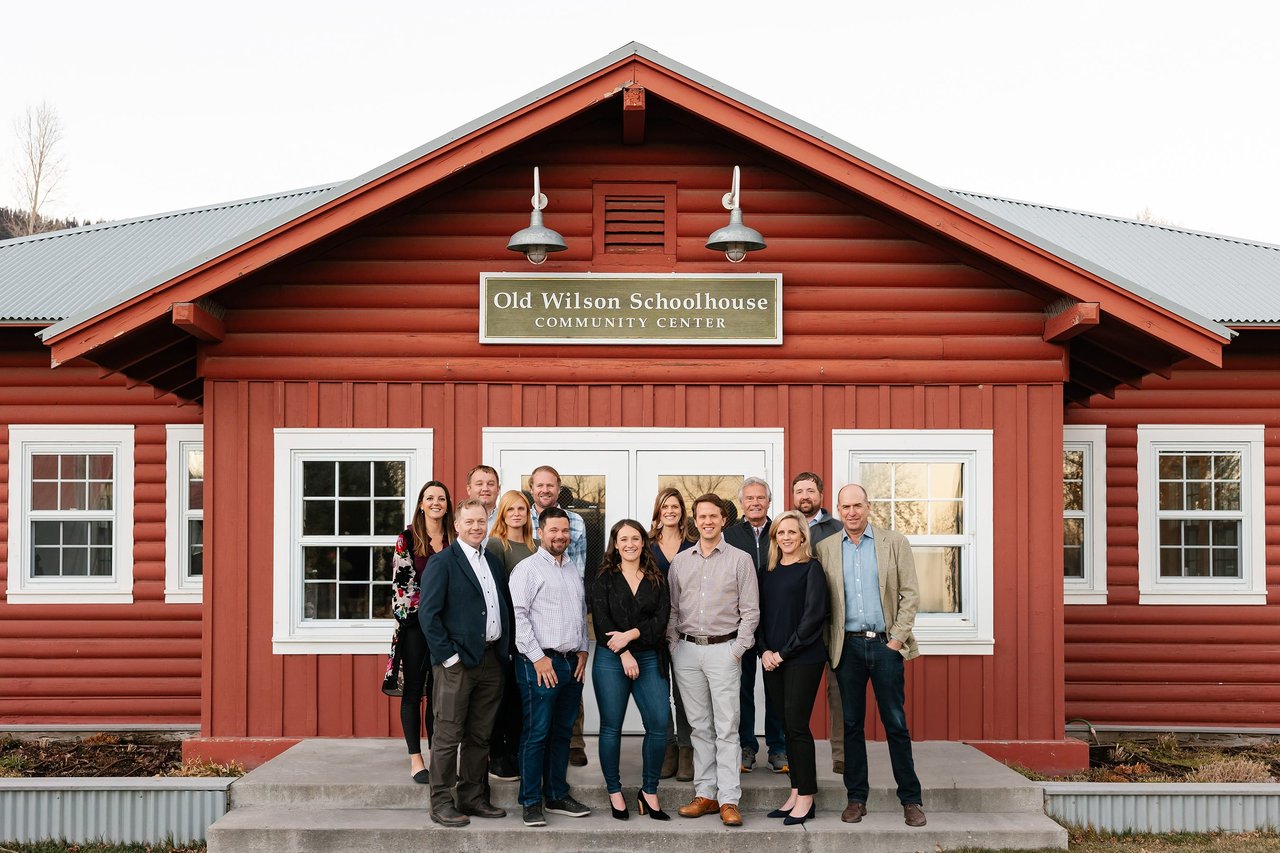 A team photo of Mountain Standard Realty in front of the Old Wilson Schoolhouse
