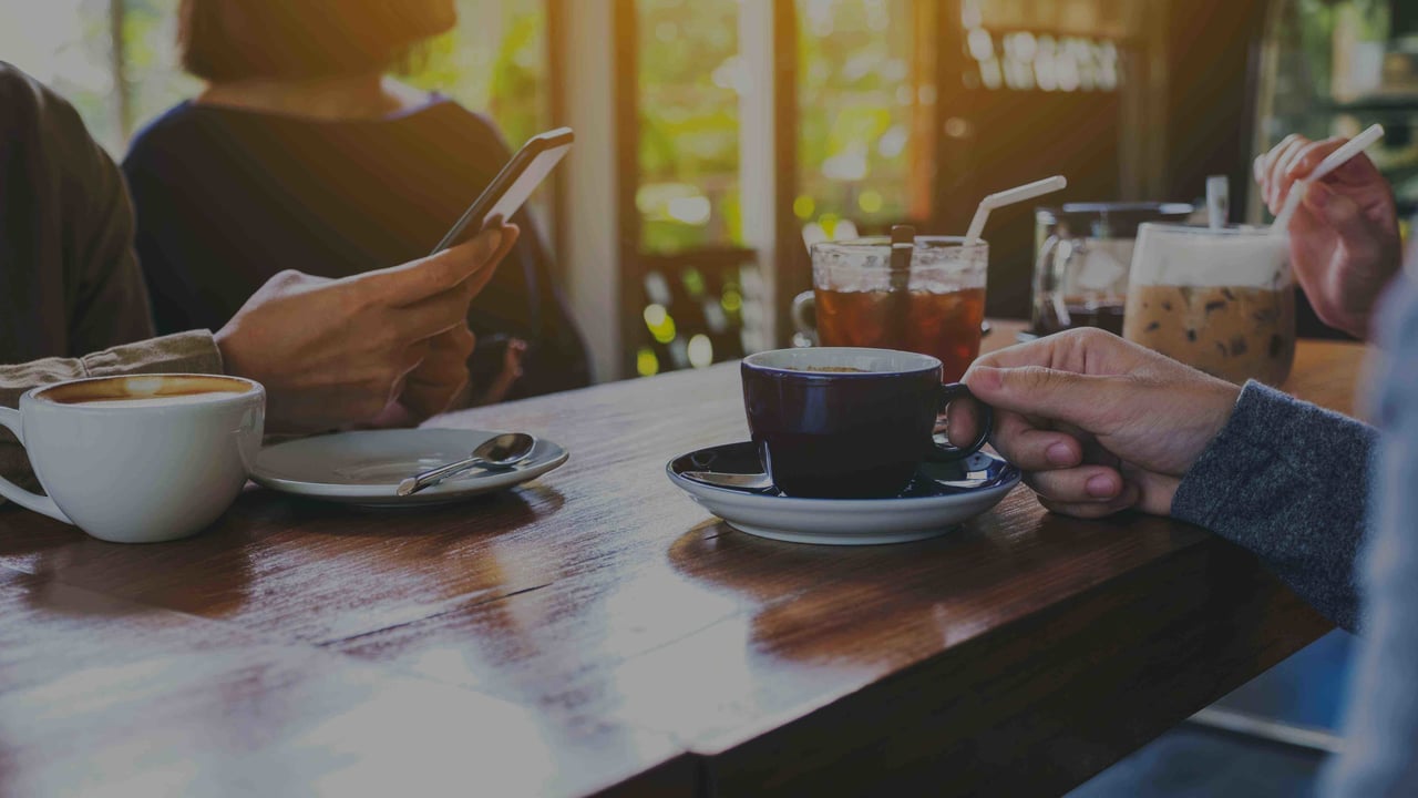 People drinking coffee and tea at a coffee shop in the early morning