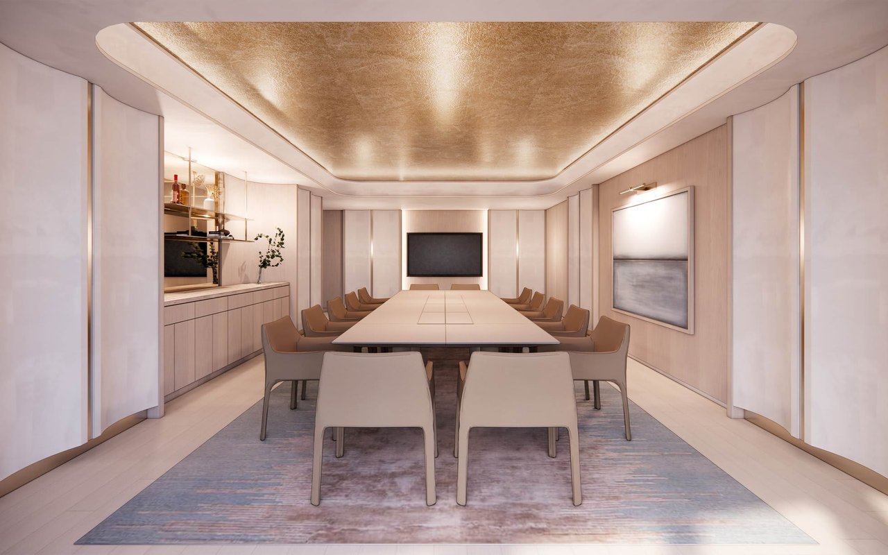 Contemporary meeting room with a long conference table, pale wood cabinetry, and a gold-toned ceiling.