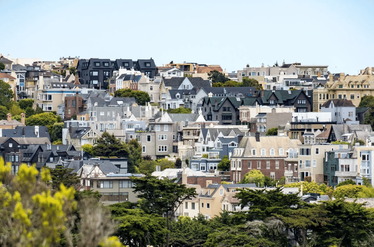 The houses are all different colors and styles, and they are all surrounded by trees.