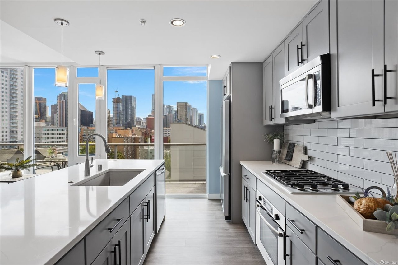 Modern luxury condo kitchen with high-end finishes and a breathtaking city skyline view.