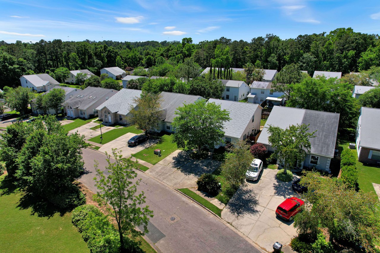 Another aerial view of the Sawgrass Plantation community, showing houses, streets, and surrounding trees.