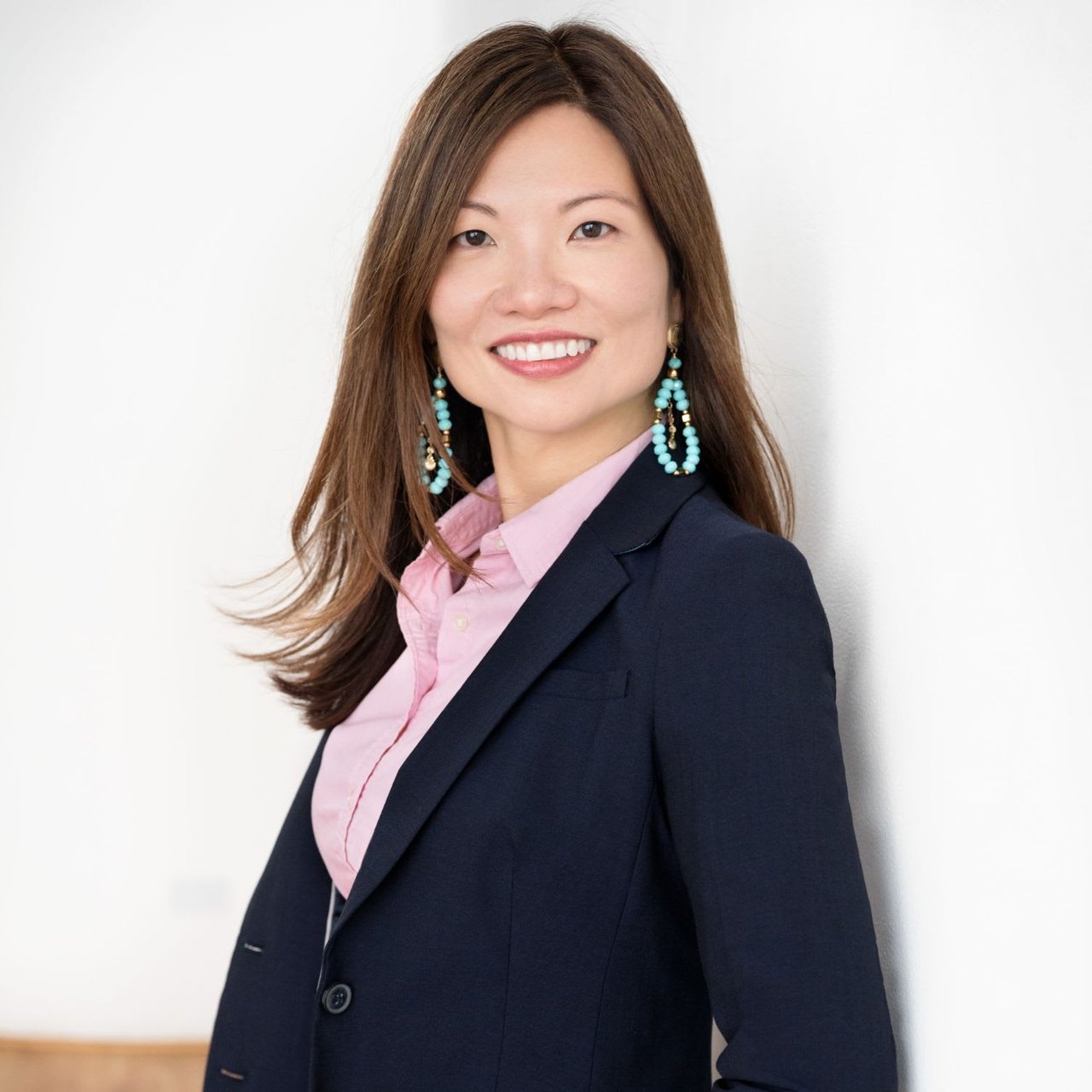 Jennifer Stuckey, a real estate expert, smiles warmly in a blue blazer and pink top.