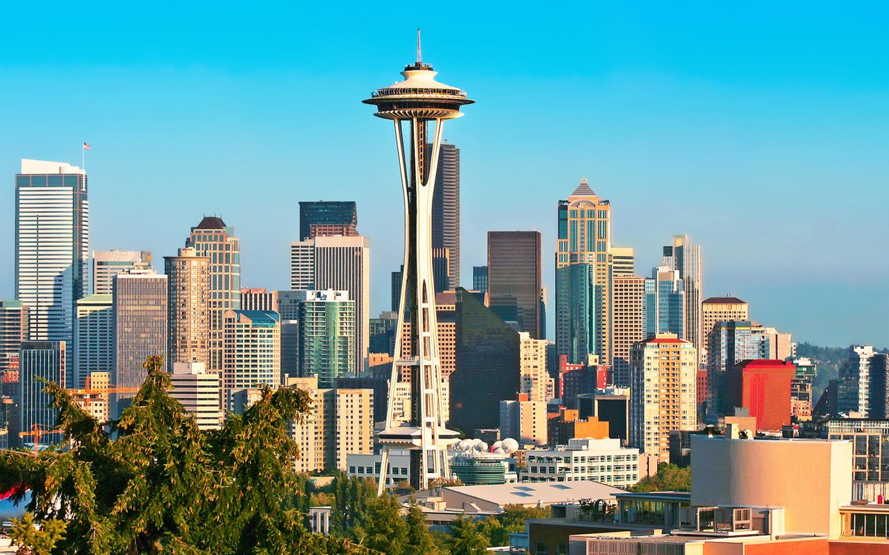  A vibrant daytime panorama of the Seattle skyline, dominated by the iconic Space Needle standing tall in the center.
