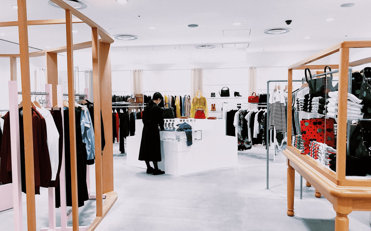 A well-lit, minimalist clothing store interior with a single person Browse. I