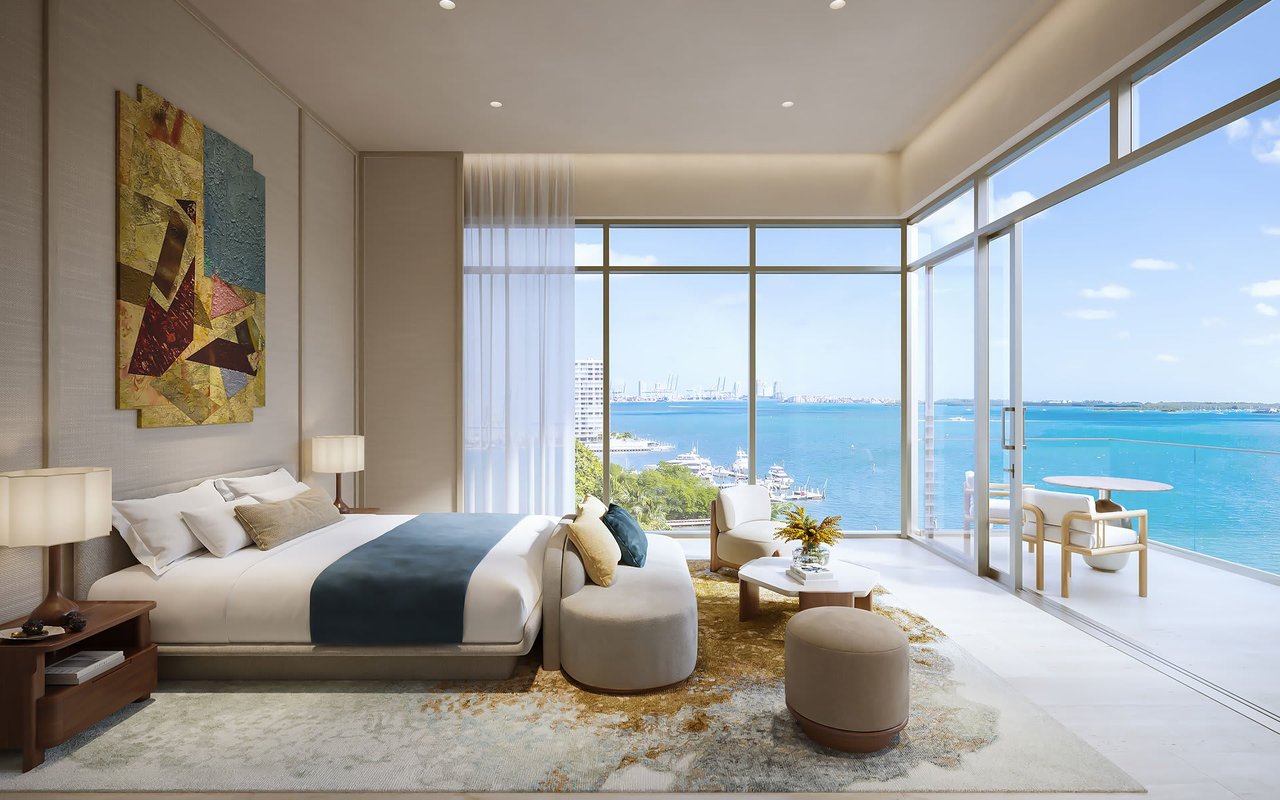 Luxury bedroom with floor-to-ceiling windows overlooking the water and Miami skyline.