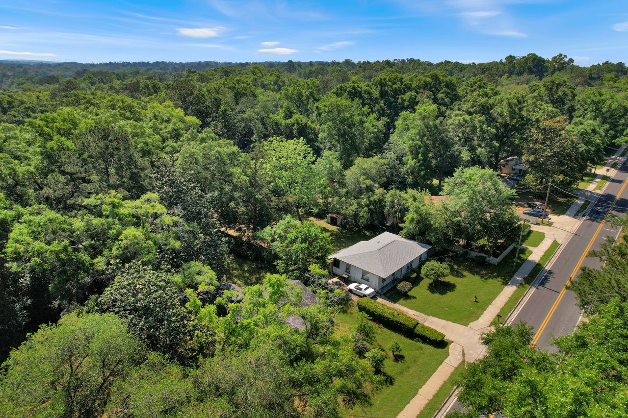 An aerial view of Seminole Manor with a house and its surrounding area. The house is set amidst a dense cover of trees, providing a private and peaceful setting.