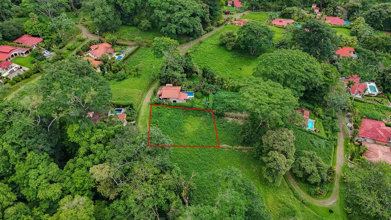 A beautiful sunny lot in a secure gated community with a nearby creek and jungle-covered valley.