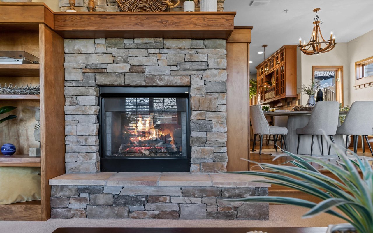 A close-up of the double-sided fireplace and solid wood built-ins.