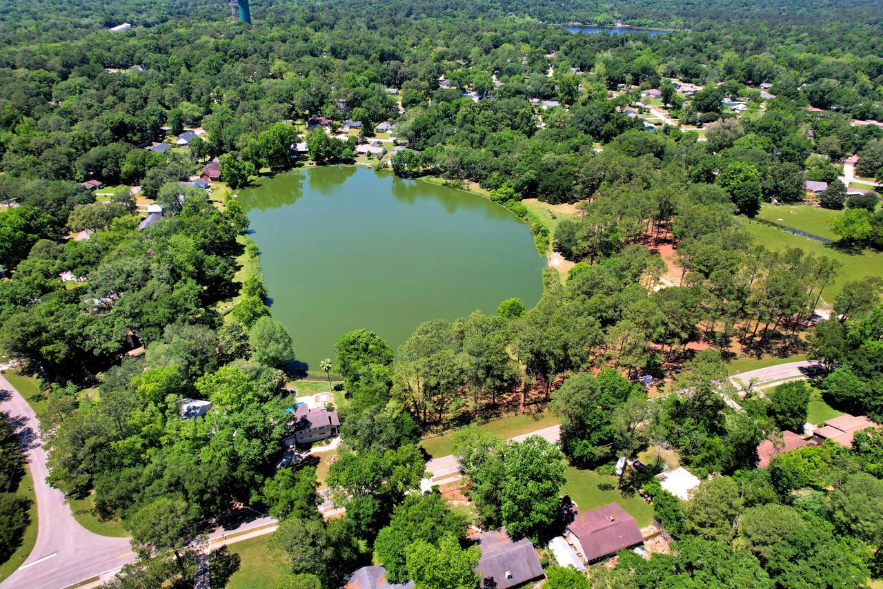 An aerial view of Killearn Acres featuring a central lake surrounded by homes and trees.