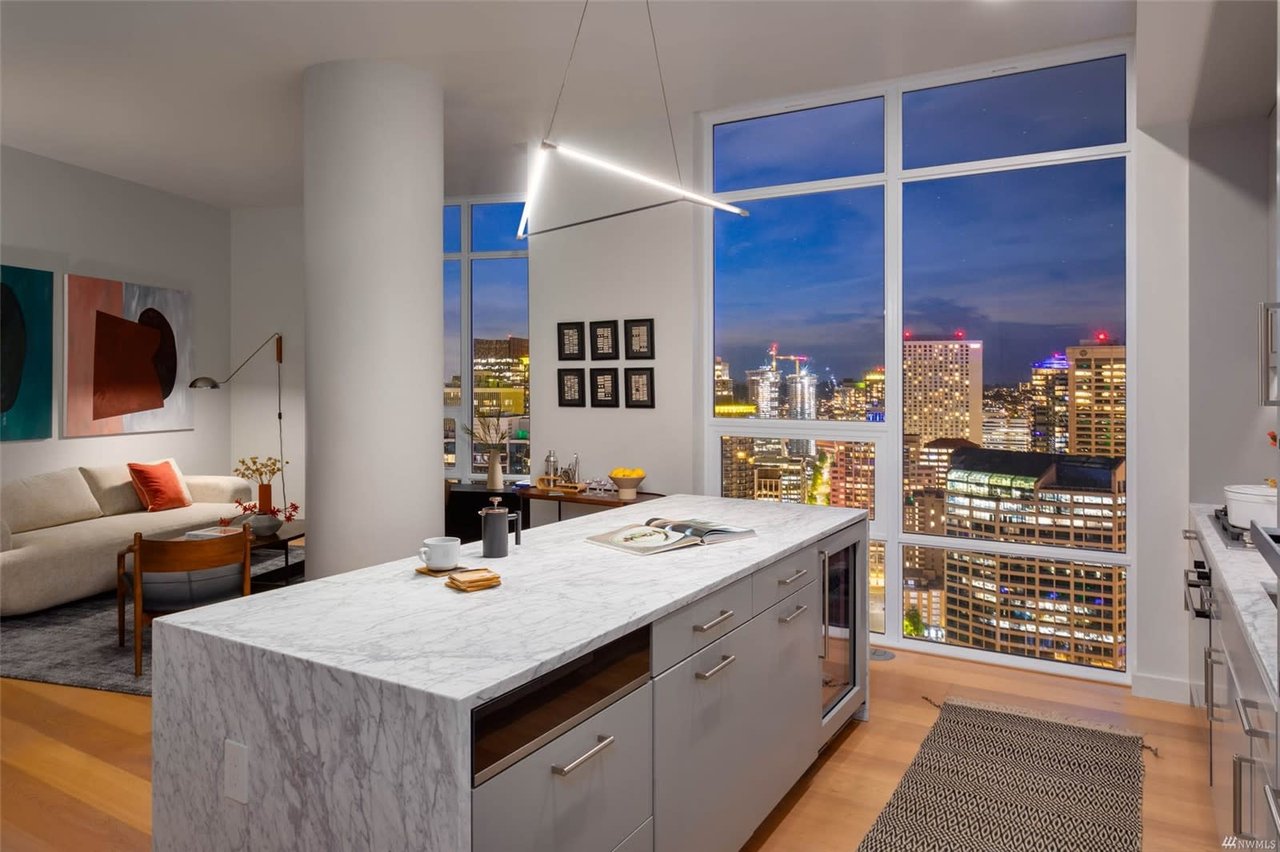 An urban kitchen with a panoramic city view showcases an elegant interior and a spacious layout.