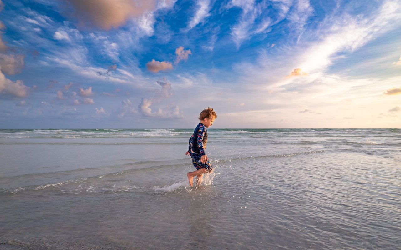 a child running in the beach shore in Lido Key Beach