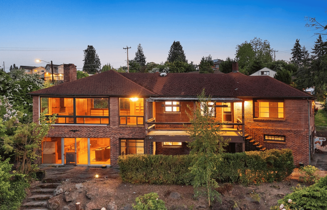 brick home at night with all internal lights on 