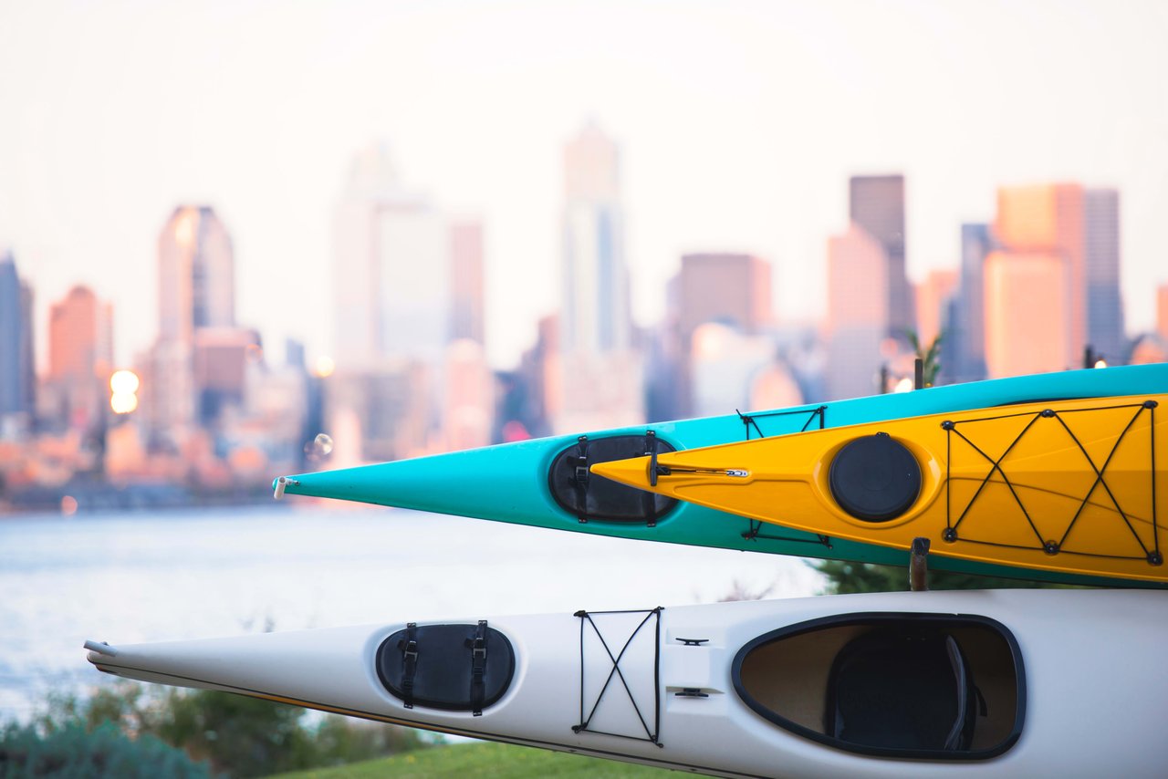 two kayaks stacked on to of each other sitting on the grass as gasworks park in Seattle