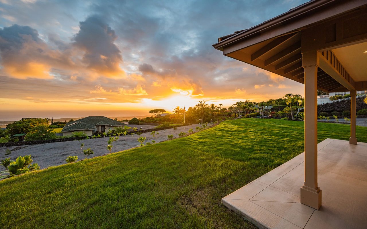 A view of the sunset from the patio, the sun is a bright orange ball sinking below the horizon