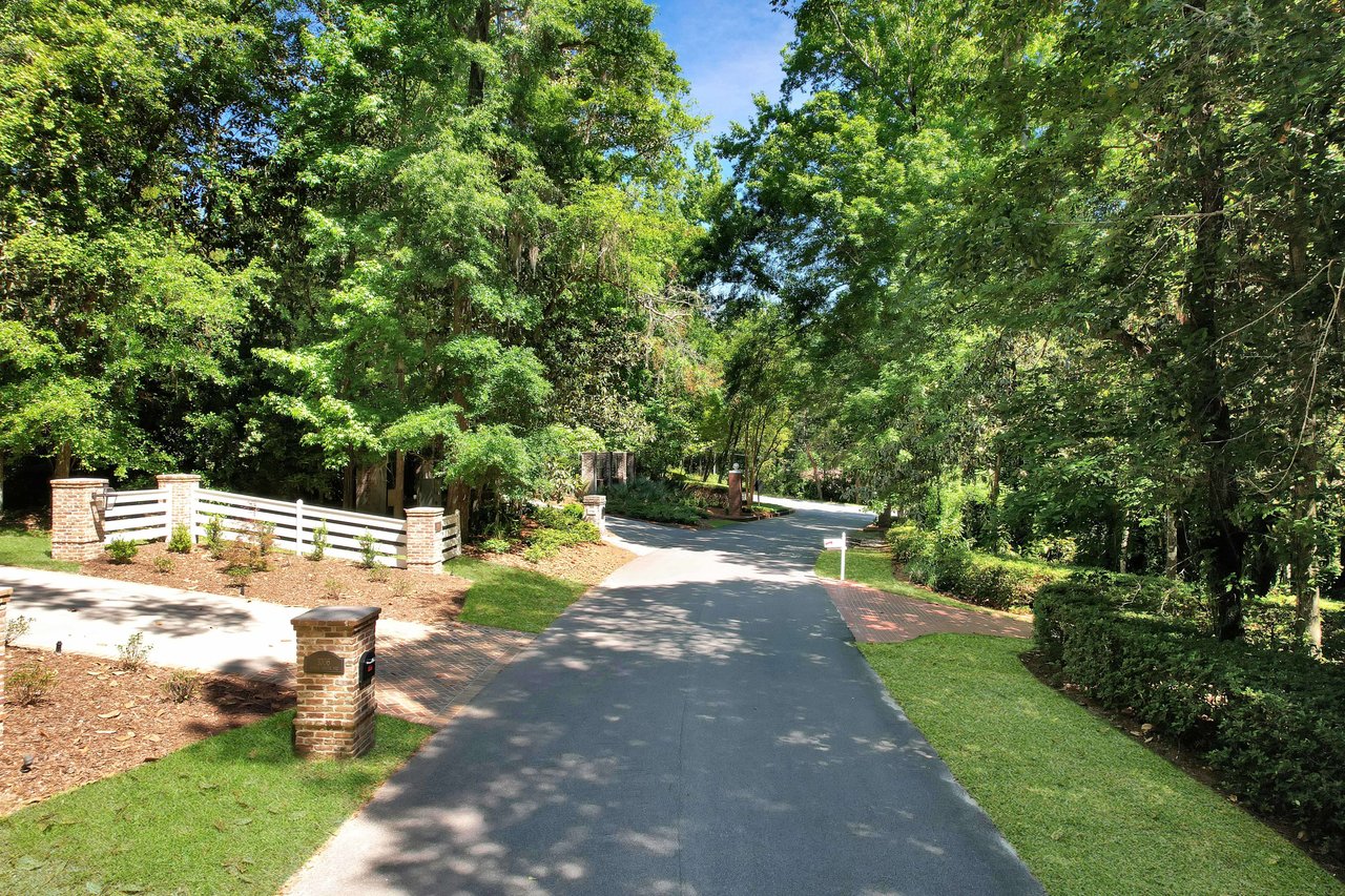 A view of a tree-lined driveway within the Bobbin Brook community, creating a picturesque entrance.
