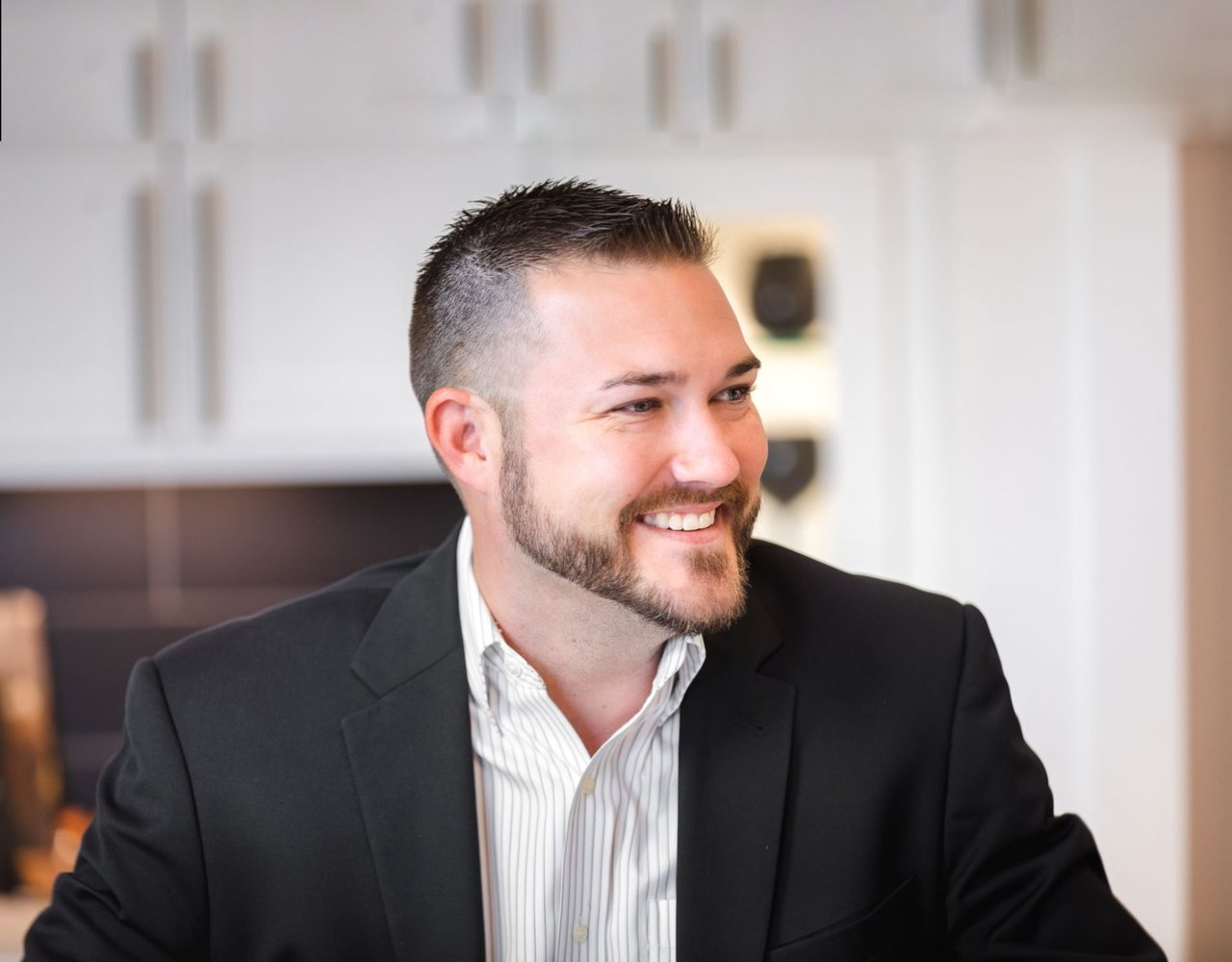 Smiling professional in a dark suit. Contact The Callander Group real estate team