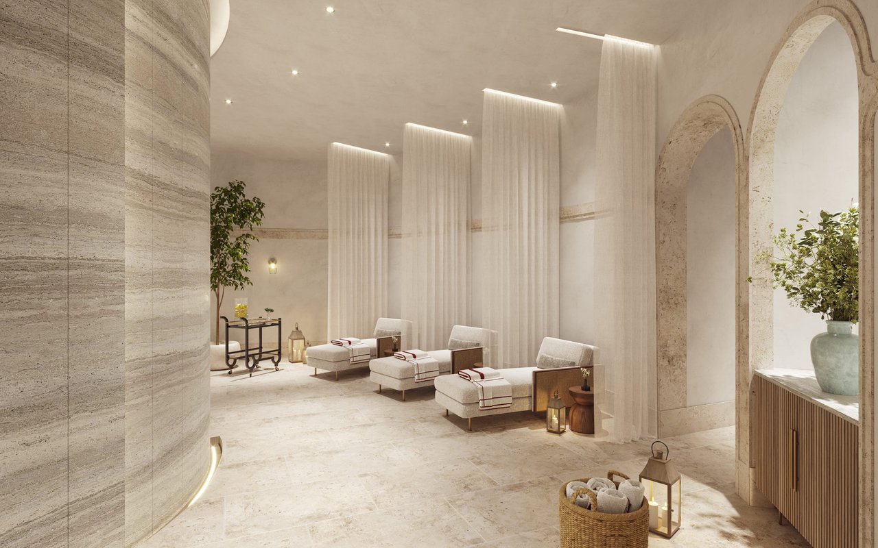 Baccarat spa lounge with three chaise lounges, sheer curtains, and pale stone arches.