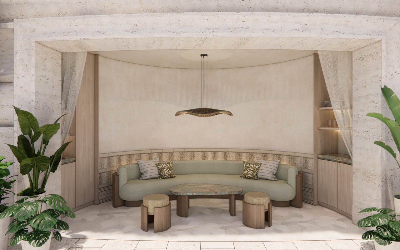 Curved sofa seating nook with a marble coffee table and tropical plants.