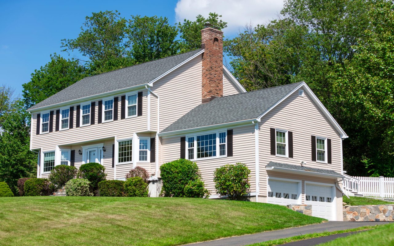 a large white house with a garage and a chimney