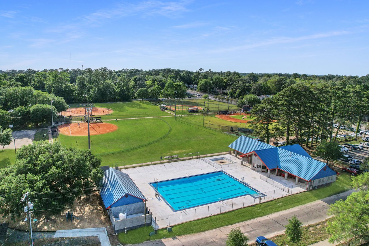 A closer aerial view of the sports complex within Levy Park, highlighting the swimming pool and baseball fields.